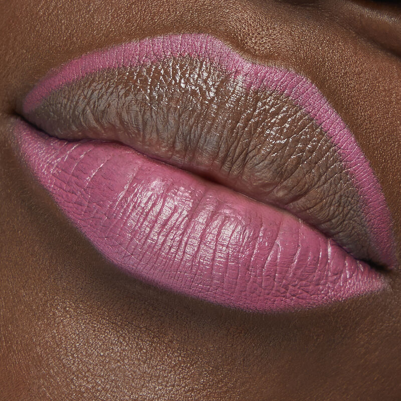 Close up of deep-skinned model with special-edition Mary Kay Waterproof Lip Liner in shade Violet Lilac outlining top lip and filling bottom lip image number null