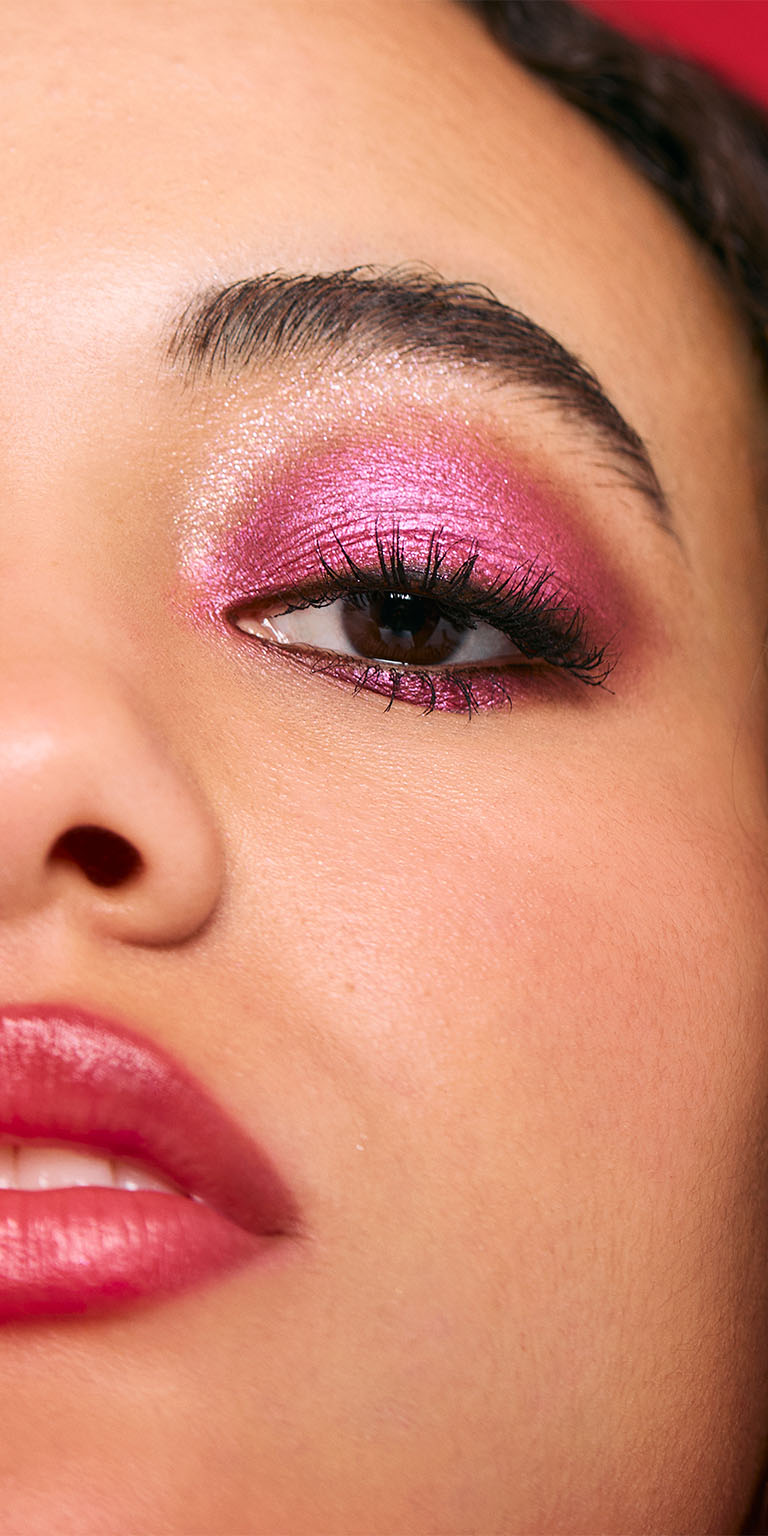 Woman with a medium skin tone wearing a purple glitter eyeshadow look